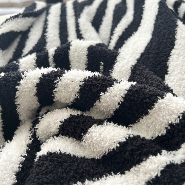 91家纺网 家纺一手货源 找家纺 苏艺针织盖毯 2024新款针织斑马纹半边绒毛毯 黑白斑马纹