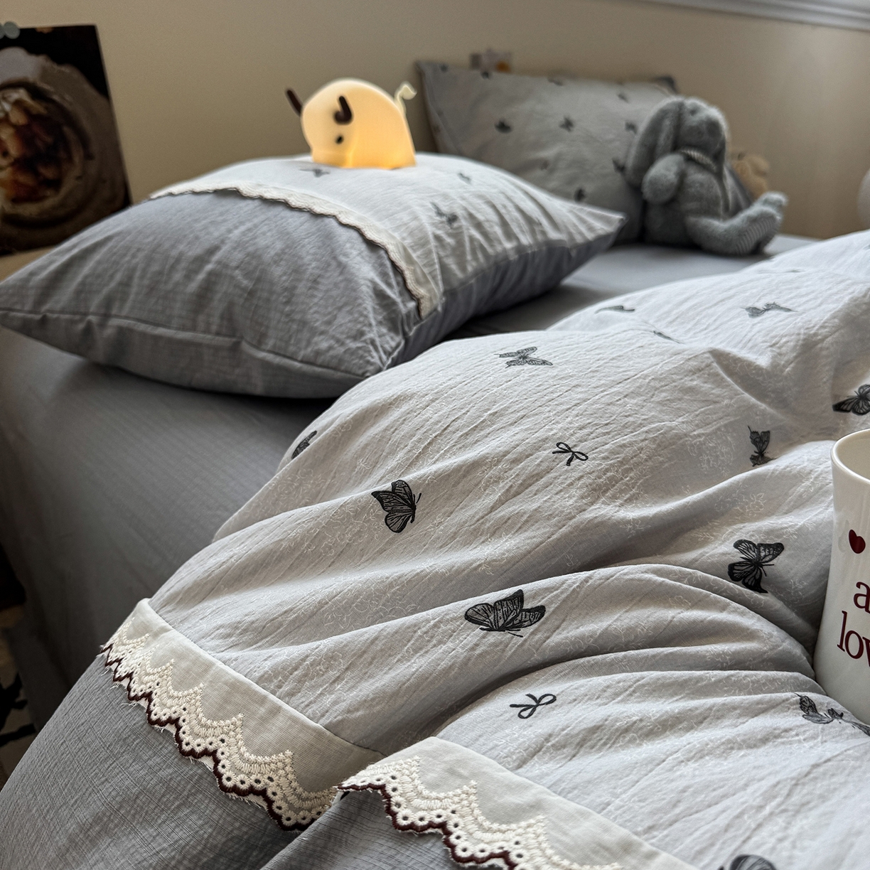 91家纺网 家纺一手货源 找家纺 水墨江南 2025新款云感皱皱纱全棉花边四件套-场景二 花边款-蝴蝶灰