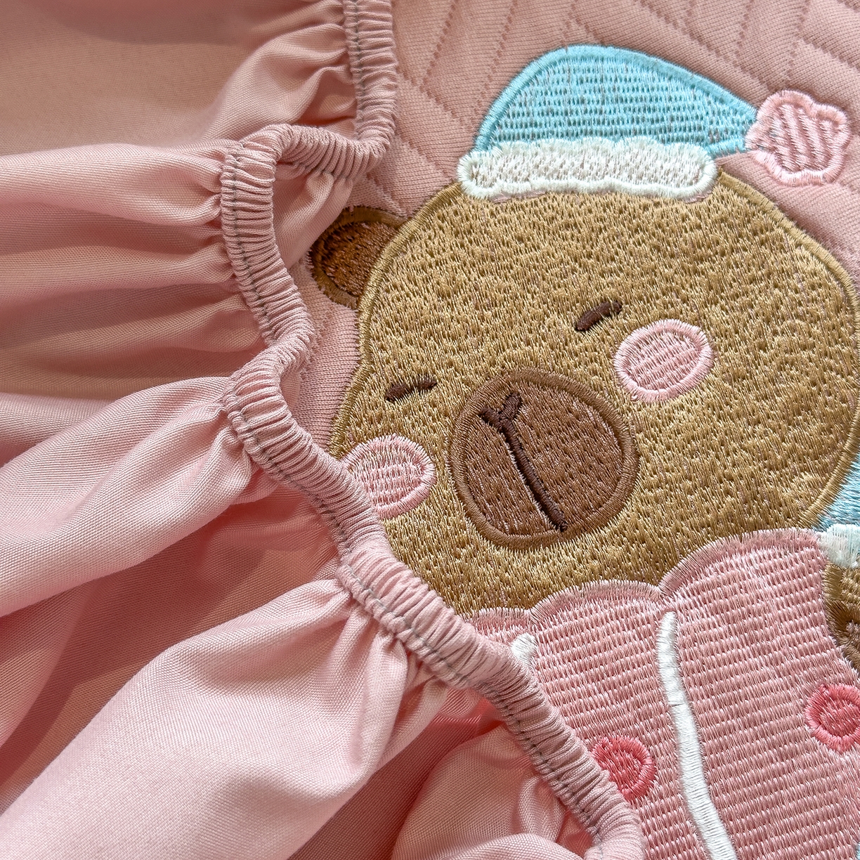 91家纺网 家纺一手货源 找家纺 眠多宝 2025新款三联刺绣卡通夹棉床笠全包围床垫保护套 欢乐卡皮巴拉-藕合粉