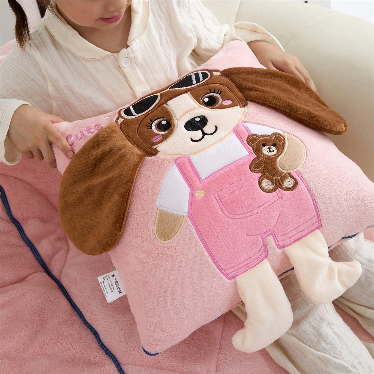 91家纺网 家纺一手货源 找家纺 吉利家居2025新款牛奶绒贴布绣多功能抱枕被-天使狗（控价小号68   大号98） 粉黛玉