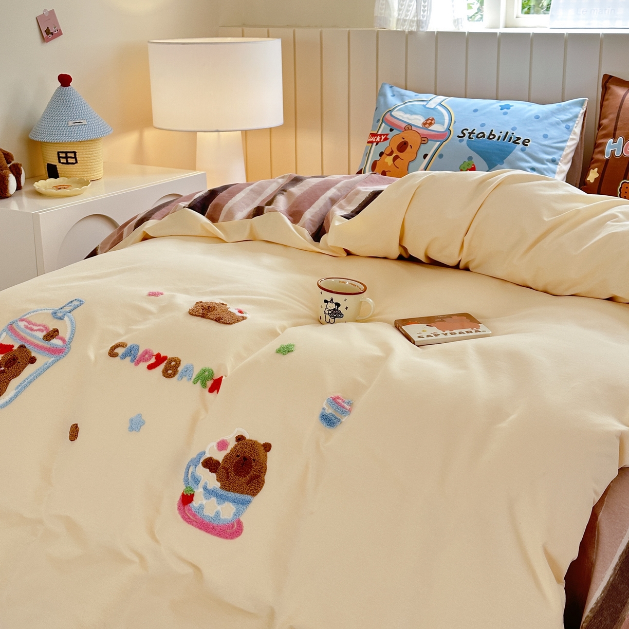 91家纺网 家纺一手货源 找家纺 优彩 2025新款数码印花全棉磨毛毛巾绣四件套 卡皮巴拉-奶咖