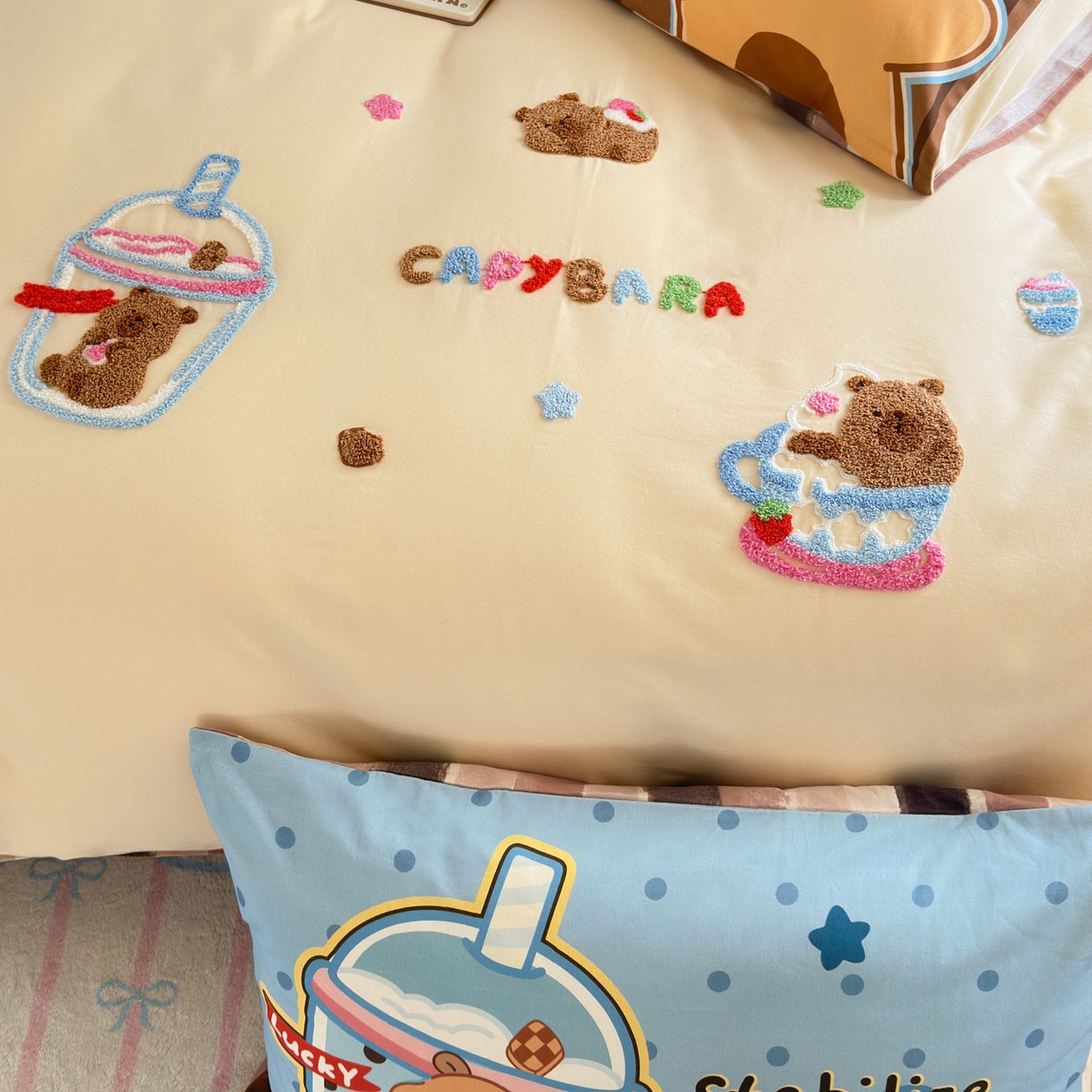 91家纺网 家纺一手货源 找家纺 优彩 2025新款数码印花全棉磨毛毛巾绣四件套 卡皮巴拉-奶咖