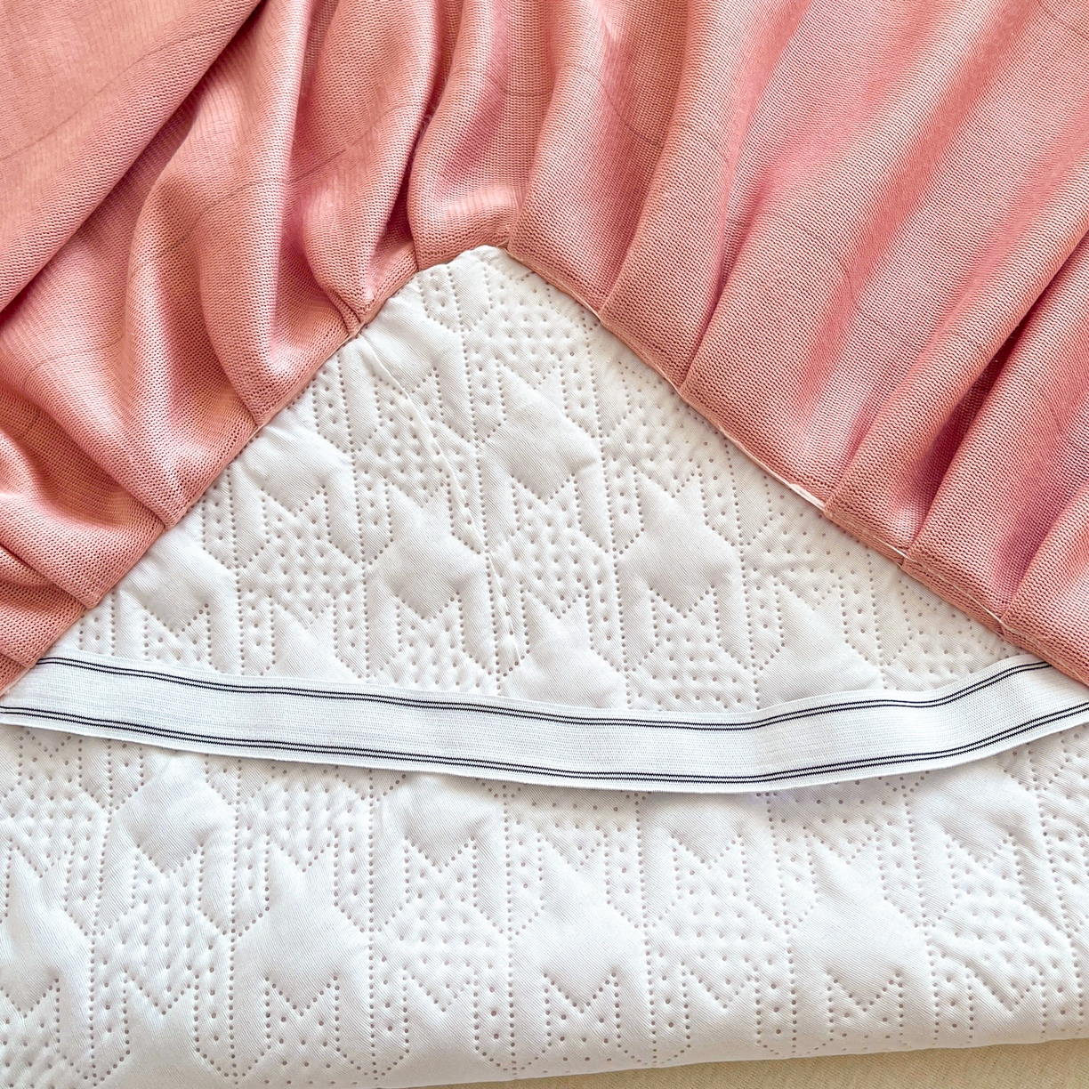 91家纺网 家纺一手货源 找家纺 卡伦家纺 2025新款抗菌雕花牛奶绒千鸟格夹棉床裙系列 千鸟格床笠-粉