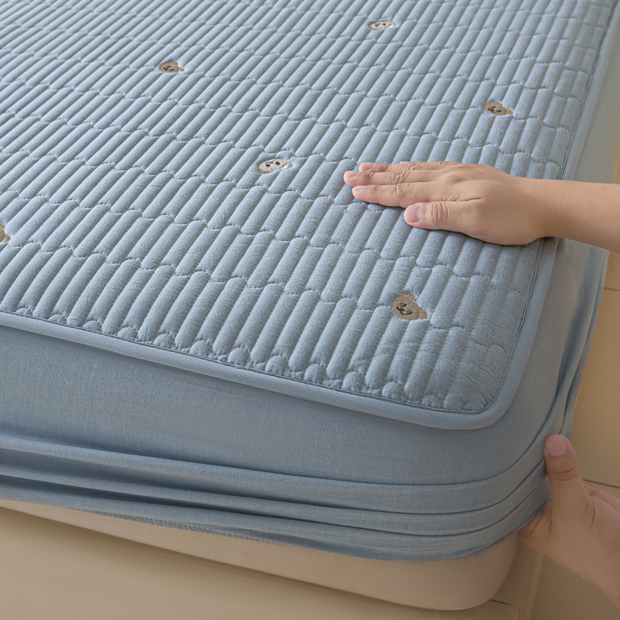 91家纺网 家纺一手货源 找家纺 卡伦家纺 2025新品全棉色织水洗棉刺绣夹棉床笠席梦思保护套小熊系列 雾蓝熊