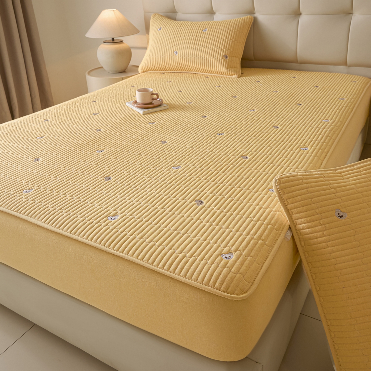 91家纺网 家纺一手货源 找家纺 卡伦家纺 2025新品全棉色织水洗棉刺绣夹棉床笠席梦思保护套小熊系列 鹅黄熊