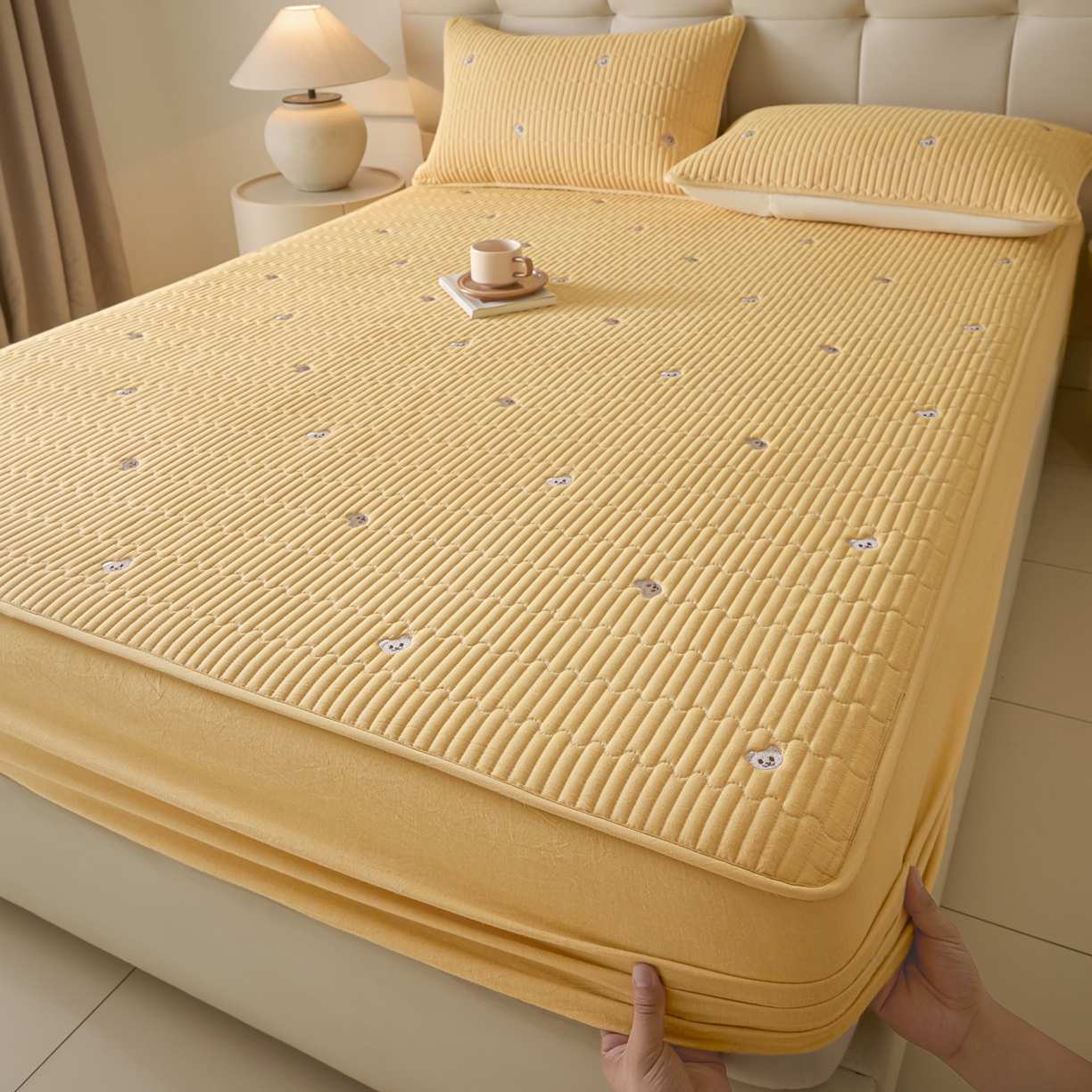 91家纺网 家纺一手货源 找家纺 卡伦家纺 2025新品全棉色织水洗棉刺绣夹棉床笠席梦思保护套小熊系列 鹅黄熊