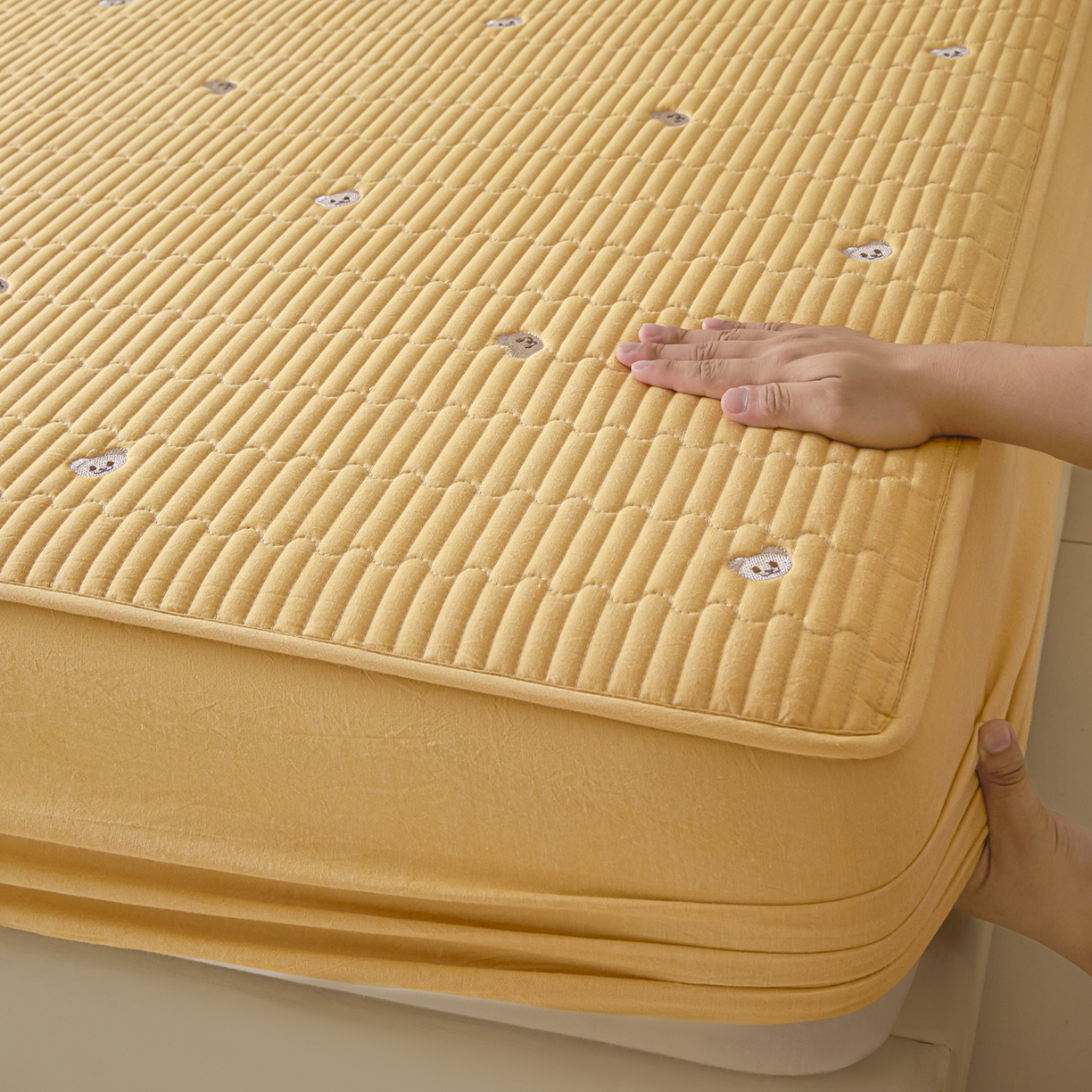 91家纺网 家纺一手货源 找家纺 卡伦家纺 2025新品全棉色织水洗棉刺绣夹棉床笠席梦思保护套小熊系列 鹅黄熊