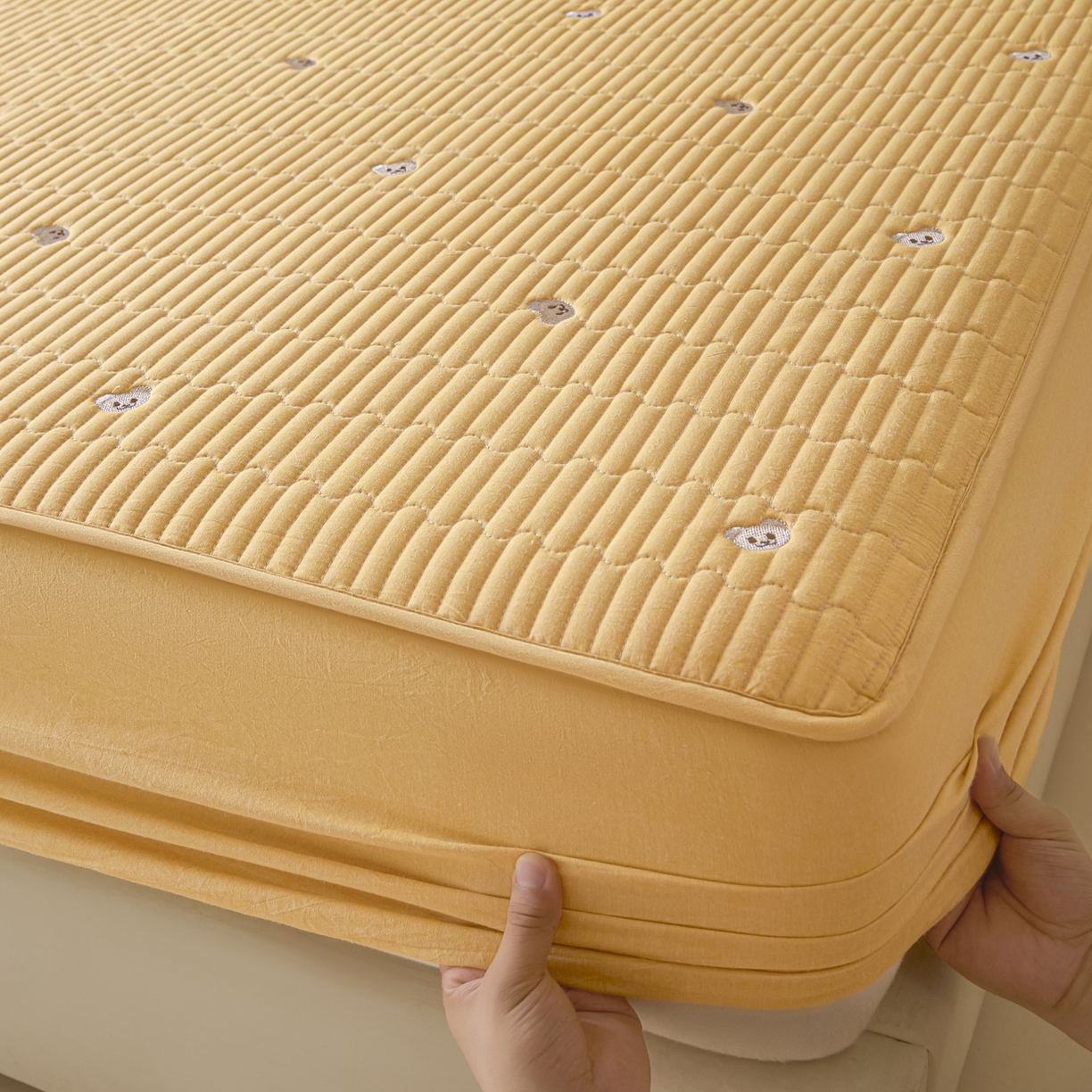 91家纺网 家纺一手货源 找家纺 卡伦家纺 2025新品全棉色织水洗棉刺绣夹棉床笠席梦思保护套小熊系列 鹅黄熊