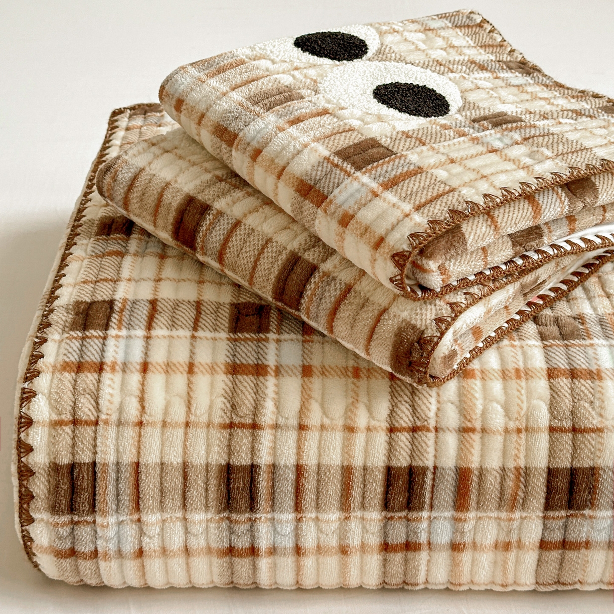 91家纺网 家纺一手货源 找家纺 （总）格真 2025新款无印风贝壳绣三角针牛奶绒床盖三件套大眼萌枕套双面可用