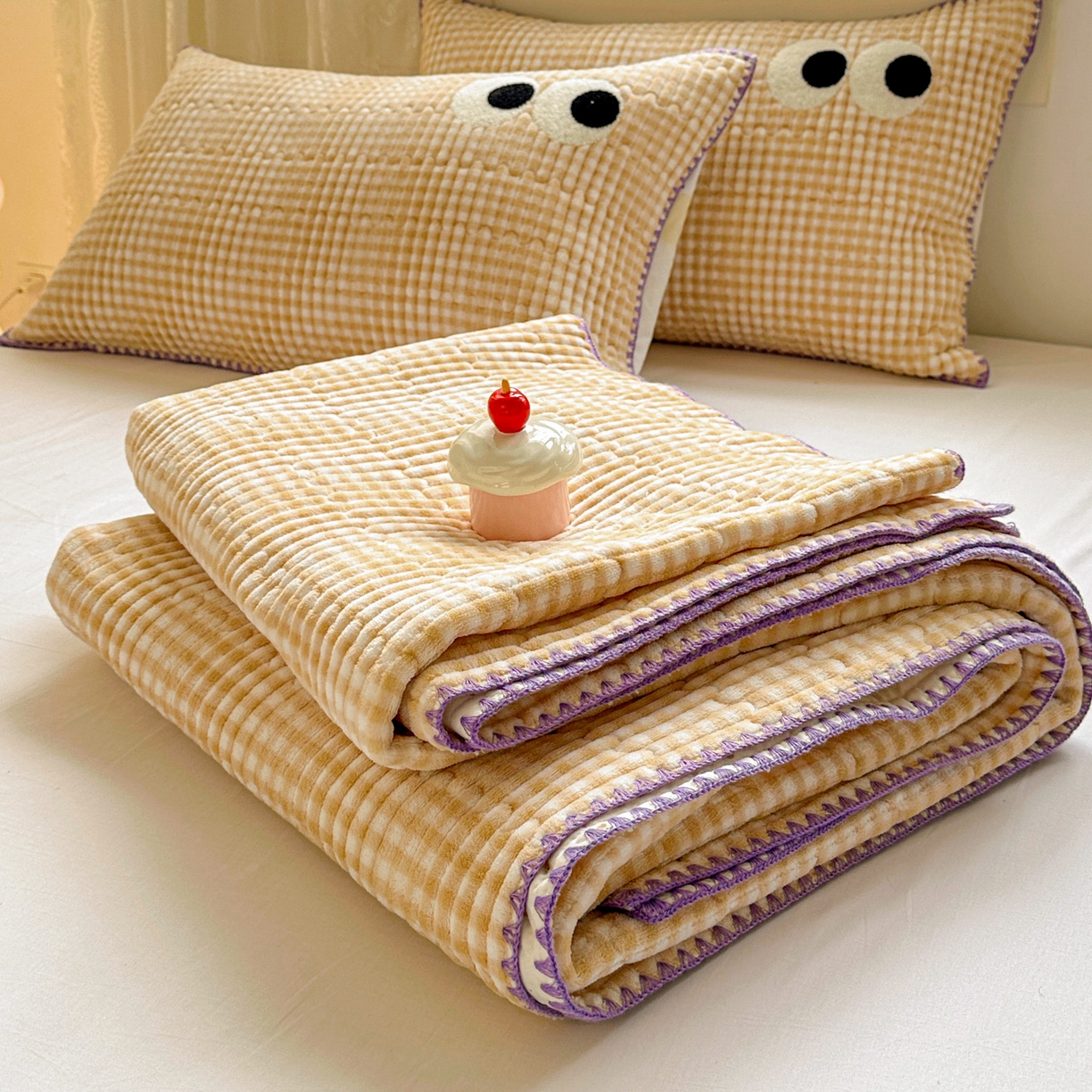 91家纺网 家纺一手货源 找家纺 格真 2025新款无印风贝壳绣三角针牛奶绒床盖三件套大眼萌枕套双面可用 米黄小格