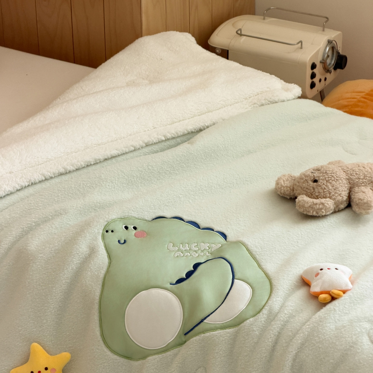 91家纺网 家纺一手货源 找家纺 喜多兔儿童家纺 2025新款圆圆系列抗菌恒温奶柔羊咩绒毯毛毯被 绿色圆滚滚的小恐龙