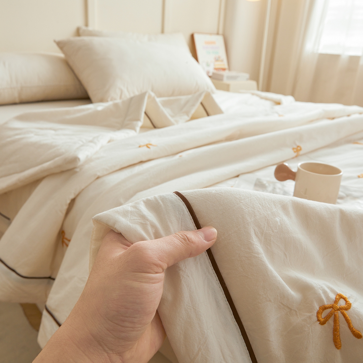 91家纺网 家纺一手货源 找家纺 仁凯家纺 2026新款A类100%棉花刺绣款手包边夏被夏凉被空调被 蝴蝶结 奶白