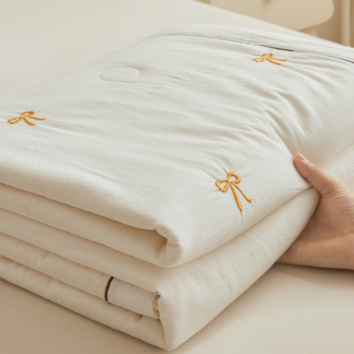 91家纺网 家纺一手货源 找家纺 仁凯家纺 2026新款A类100%棉花刺绣款手包边夏被夏凉被空调被 蝴蝶结 奶白