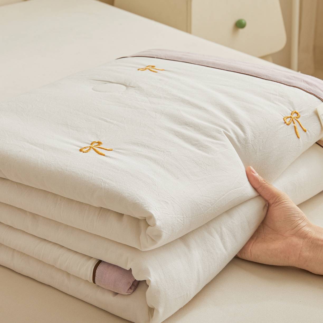 91家纺网 家纺一手货源 找家纺 仁凯家纺 2026新款A类100%棉花刺绣款手包边夏被夏凉被空调被 蝴蝶结 奶白拼雾紫