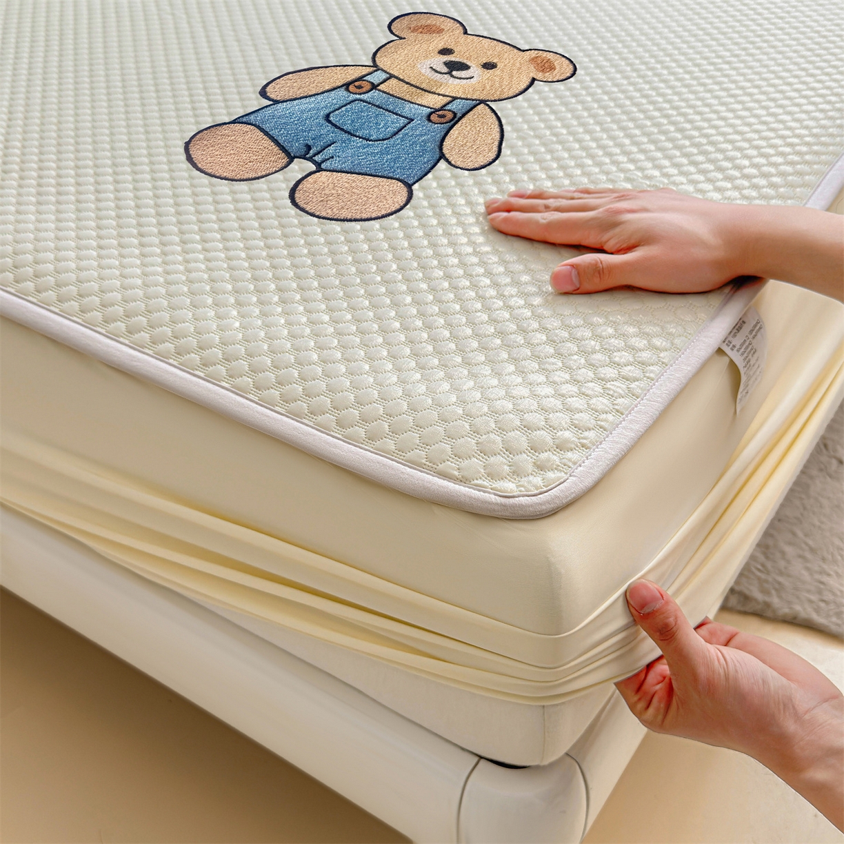 91家纺网 家纺一手货源 找家纺 雯豆家纺 2026新款夏季绣花三明治凉豆豆压花床笠三件套加厚床罩床垫保护套 背带熊床笠款-米黄