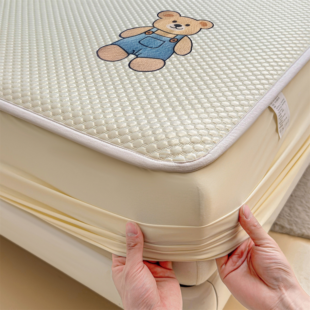 91家纺网 家纺一手货源 找家纺 雯豆家纺 2026新款夏季绣花三明治凉豆豆压花床笠三件套加厚床罩床垫保护套 背带熊床笠款-米黄