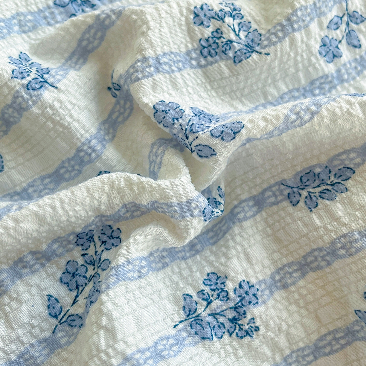 91家纺网 家纺一手货源 找家纺 金梦拉家纺 2026新款全棉花边系列泡芙纱泡泡纱夏被夏凉被空调被四件套 浅蓝花照